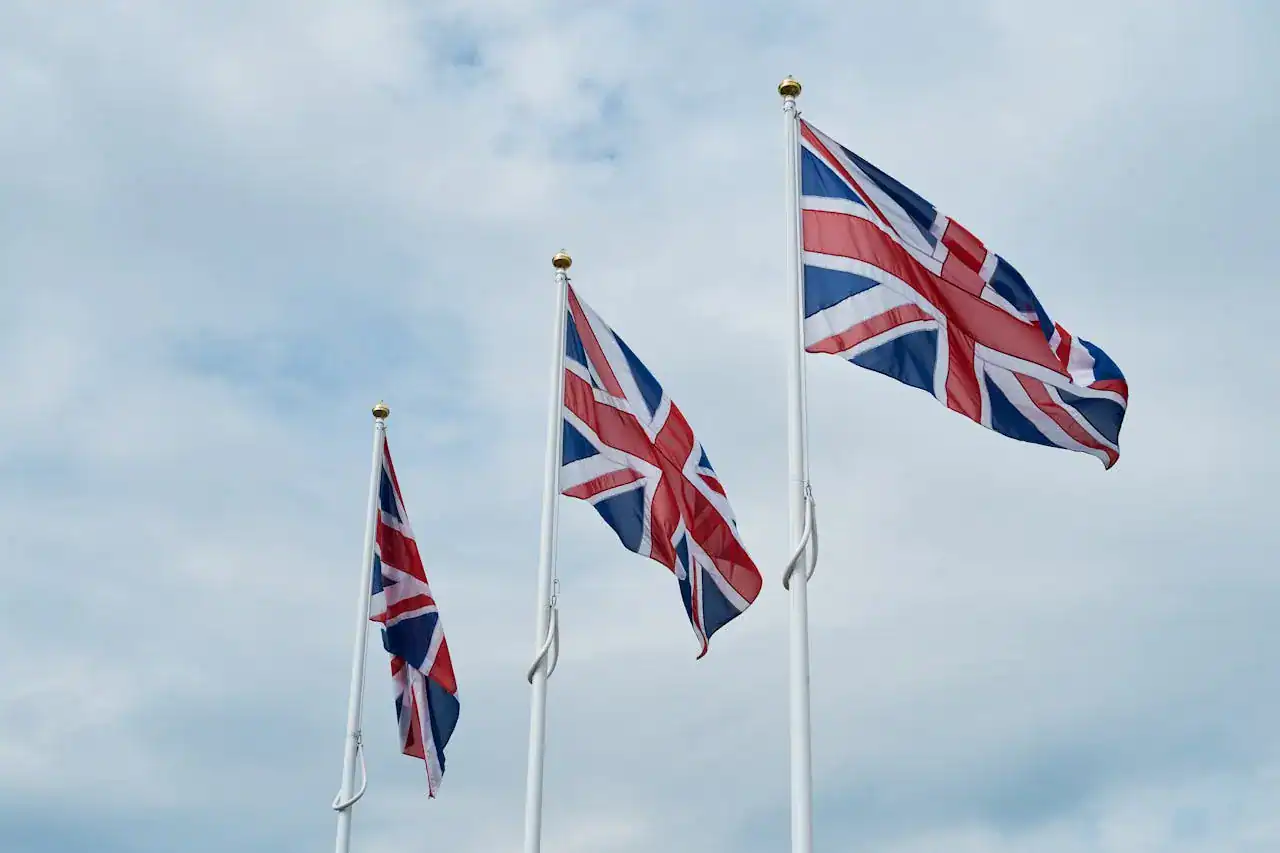 British flags flying outdoors under a cloudy sky, representing UK trade and industry.